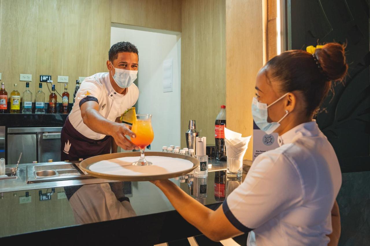 Caribe Deluxe Princess Punta Cana Bagian luar foto A waiter serving a drink